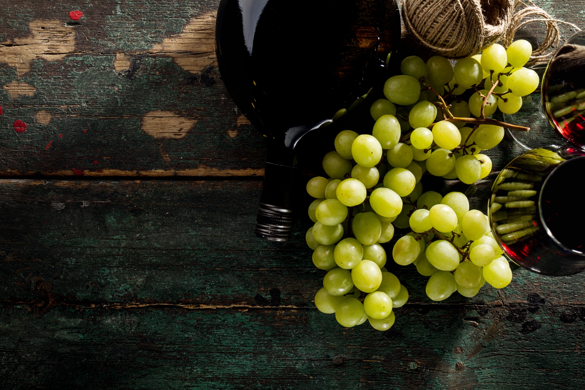 Tasty fresh red wine in glass with grape and wine bottle Free Photo