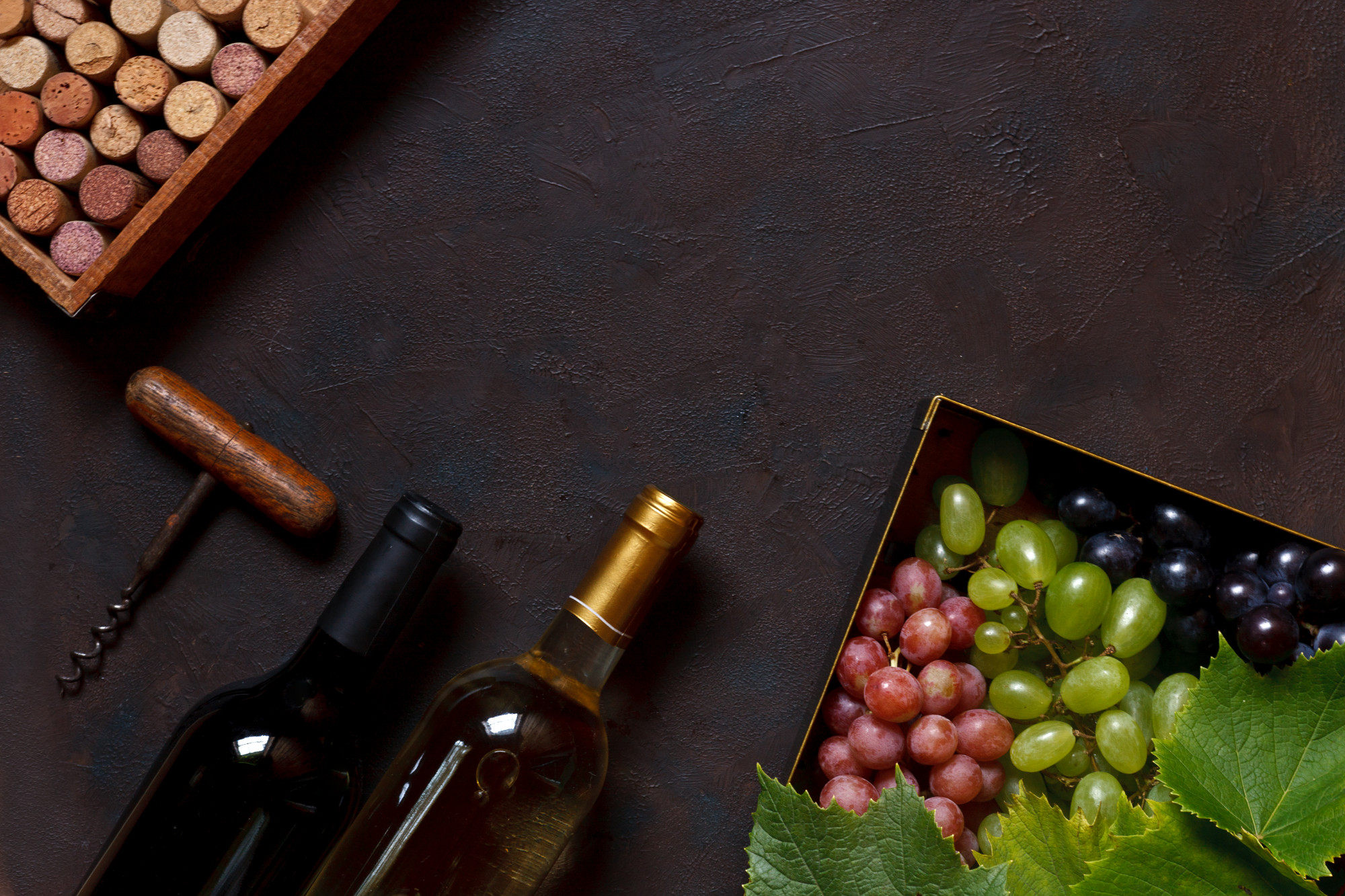 Red, green and blue grapes with leaves in metal box Premium Photo